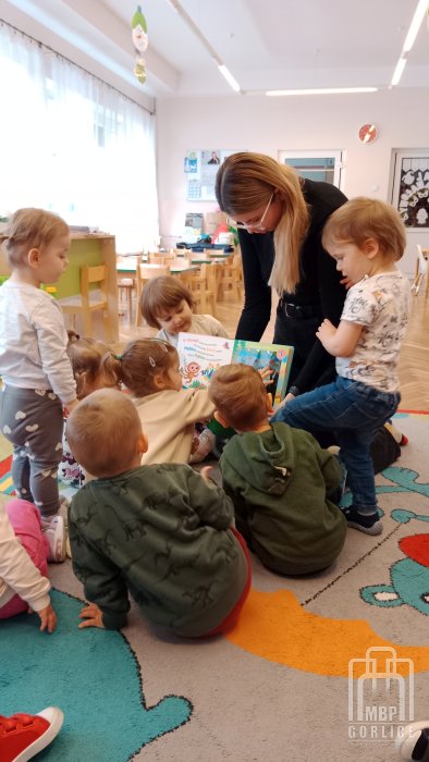 Biblioteka Gorlice, Pierwsze kroki… w świecie książek Bibliotekarka prezentuje książkę z lataką.jpg